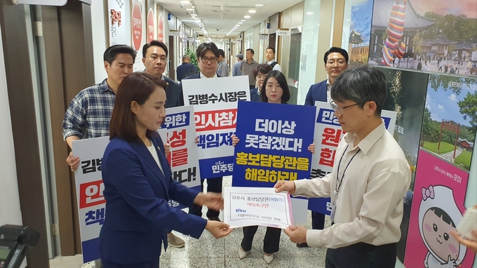 김포시의회 더불어민주당 소속 의원들이 시장실을 찾아 관계자에게 홍보담당관 해임 촉구안을 전달 하고 있다. (사진=천용남 기자)