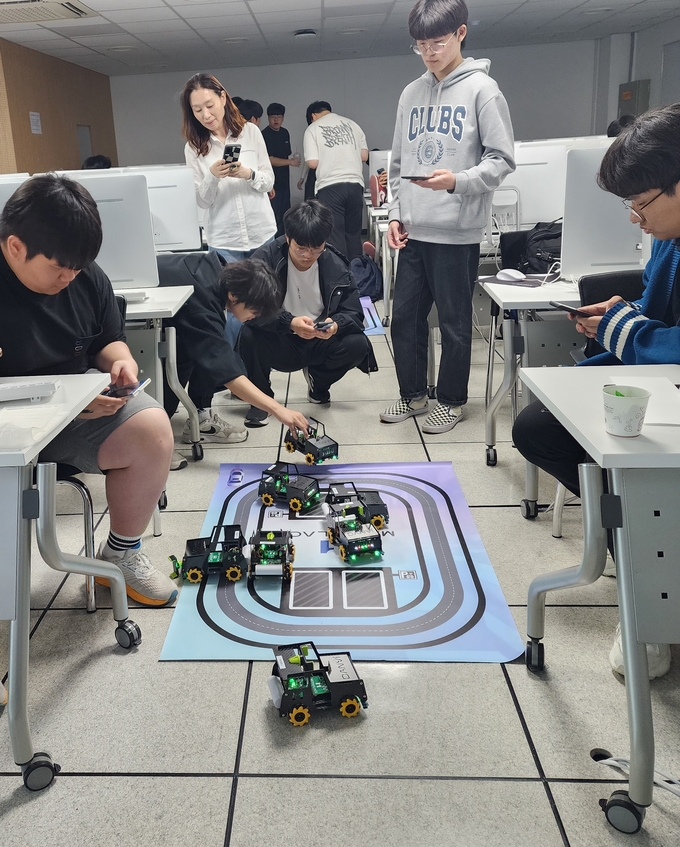 성남고등학교 학생들과 선생님이 반도체대학 511호 실습실에서 스마트폰으로 블루투스를 연결하여 AI 로봇 단비의 자율 주행 실습을 체험하고 있다. (사진=가천대 제공)