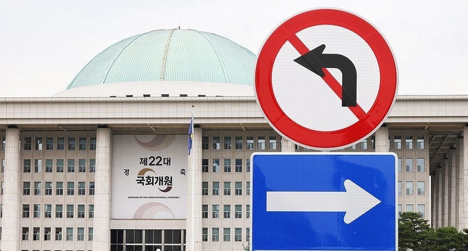 22대 국회가 4년 임기를 시작한 5월 30일 본청에 걸린 ‘제22대 국회 개원 축하 현수막’이 국회 정문 앞에 설치된 교통 표지판 너머로 보이고 있다. (사진=연합뉴스)