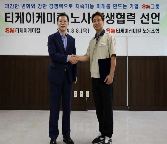 (왼쪽부터)이동수 대표이사와 정순열 노조위원장이 지난 8일 경북 구미시 티케이케미칼 구미공장에서 열린 노사 상생협력 선언식에 참석해 악수하며 기념촬영을 하고 있다. (사진=SM그룹 제공)