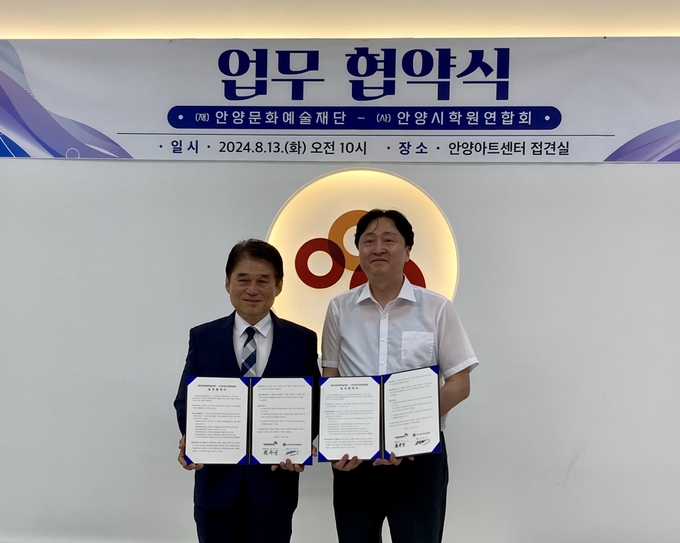 최우규 안양문화예술재단 대표이사(왼쪽)과 김범수 안양시학원연합회 회장이 13일 안양아트센터에서 업무협약을 한 뒤 기념촬영을 하고 있다. (사진=안양문화예술재단 제공)