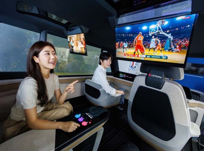  'K-디스플레이 2024' 전시회에서 LG디스플레이 모델이 18인치 슬라이더블 OLED 및 57인치 필러투필러 LCD가 적용된 자율주행 콘셉트카를 체험하고 있다. (사진=LG디스플레이 제공)