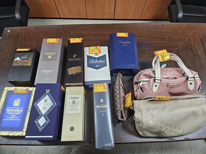 안양시가 지방세 상습 체납자의 가택을 수색해 압류한 명품 가방과 양주.(사진=안양시 제공)