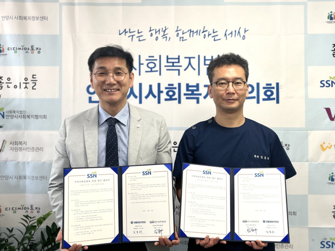 도준우 안양시사회복지협의회 회장(왼쪽)과 김용희 서울와이즈치과 대표원장이 협약을 맺은 뒤 협약서를 들어보이고 있다. (사진=안양시사회복지협의회 제공)