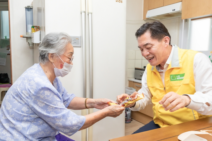 수원새빛돌봄을 이용하고 있는 강 씨(92)가 이재준 시장에게 아이스크림을 건네는 모습. (사진=수원시 제공)