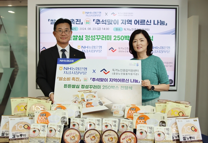 서준호 농협은행 자금시장부문 겸 에셋전략부문 부행장(왼쪽)과 김현미 독거노인종합지원센터장이 지난 23일 열린 나눔행사에서 기념촬영을 하고 있다. (사진=NH농협은행 제공)