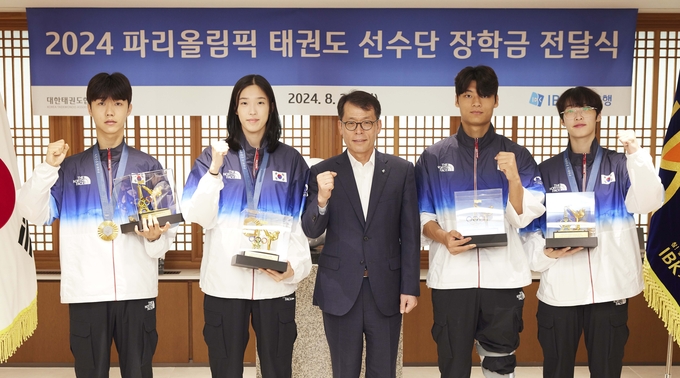 김성태 IBK기업은행장(가운데)이 2024 파리올림픽 태권도선수단 장학금 전달식에서 태권도 선수단과 기념촬영을 하고 있다. (사진=기업은행 제공)
