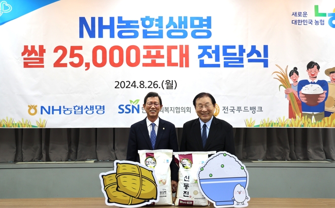 윤해진 NH농협생명 대표이사가 김성이 한국사회복지협의회장과 쌀 전달식 후 기념촬영을 하고 있다. (사진=NH농협생명 제공)