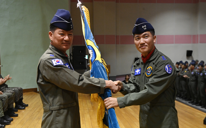 30일 오전 수원시 공군10전투비행단 수원기지 필승체육관에서 열린 '153대대 해체행사'에서 김태형 대대장(중령)이 김훈경 10전비단장(준장)에게 부대기를 반납하고 있다.