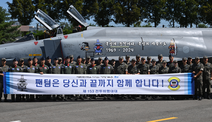 30일 오전 수원시 공군10전투비행단 수원기지 필승체육관에서 열린 '153대대 해체행사'를 마치고 김훈경 공군10전투비행단장(준장)과 김태형 153대대장 및 대대원들이 기념촬영을 하고 있다.