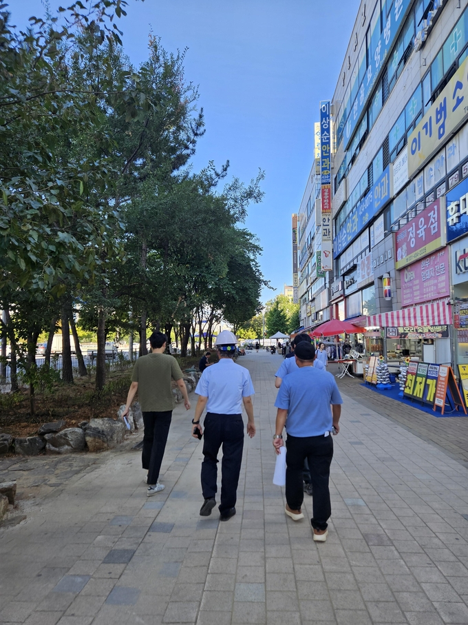 시흥시는 대표 골목상권인 옥구상가에 지난 8월 29일에는 사업의 진행 상황을 점검하기 위해 시흥시 소상공인과장을 비롯한 건설행정과 감독공무원 및 팀장, 감리, 시공사 대표 등 사업관계자들이 함께 현장을 찾았다. 이들은 설치된 벽걸이(행잉) 조명 등 시설물을 점검하고 공사 전반에 관해 확인했다. (사진=시흥시 제공)