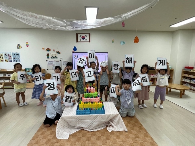 모담 유치원 개원 기념식에 원아들이 많이 사랑한다는 글을 쓴 종이를 들어보이고 있다. (사진=모담유치원 제공) 