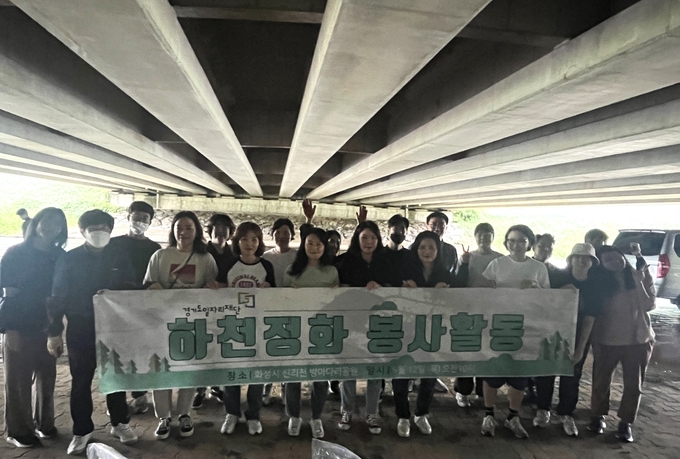 12일 화성시 실리천에서 경기도일자리재단 하천정화 봉사활동 참여자들이 기념촬영을 하고 있다. (사진=경기도 제공)