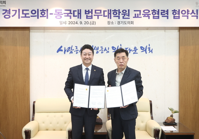 김진경(왼쪽) 경기도의회 의장과 임규철 동국대 법무대학원장이 20일 경기도의회에서 열린 교육협력 협약식에서 협약서를 들고 기념촬영을 하고 있다. (사진=경기도의회 제공)