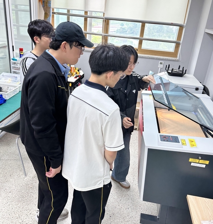 갈매고등학교 학생 메이커 운영관리팀이 레이저 커팅기의 사용방법을 배우고 있다. (사진=갈매고등학교 제공)