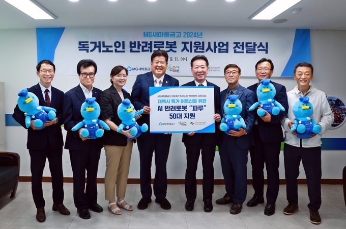 이상호 태백시장(왼쪽 4번째)과 한상기 새마을금고중앙회 강원지역이사(왼쪽 5번째) 및 관계자들이 인공지능 반려로봇 전달식에서 기념촬영을 하고 있다. (사진=새마을금고중앙회 제공)