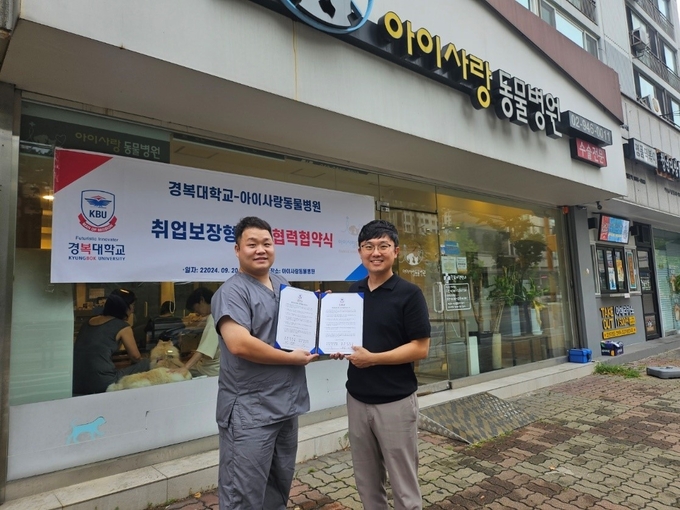 경복대학교 반려동물보건과 정연수 교수와 아이사랑동물병원 김규환 대표원장이 산학협력을 위한 MOU 체결서를 들어보이고 있다. (사진=경복대 제공)