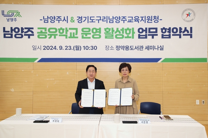 주광덕(왼쪽) 남양주시장과 서은경 구리남양주교육지원청 교육장이 공유학교 운영 활성화를 위한 업무협약서를 들어보이고 있다. (사진=남양주시 제공)