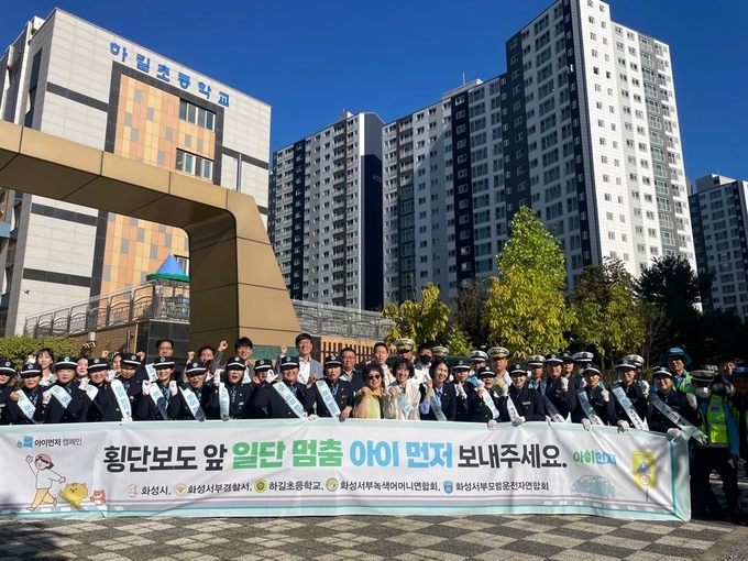 화성서부경찰서는 24일 오전 하길초등학교에서 ‘횡단보도 앞 일단 멈춤 아이 먼저 보내세요’ 교통사고 예방 홍보활동을 펼쳤다. (사진=화성서부경찰서 제공)