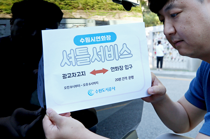 25일 수원시연화장 직원이 셔틀서비스 안내판을 부착하고 있는 모습. (사진=수원도시공사 제공)