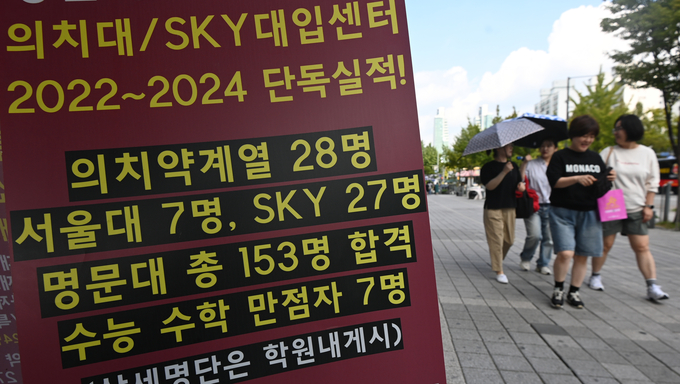 26일 안양시 동안구 학원가에서 학부모와 자녀들이 전년도 입시 결과 홍보문구가 붙어 있는 학원 앞을 지나치고 있다.