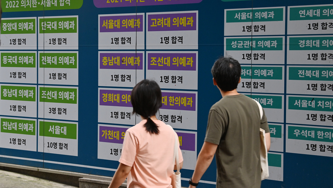 26일 안양시 동안구 학원가에서 학생들이 전년도 입시 결과 홍보문구가 붙어 있는 학원 앞을 지나치고 있다.