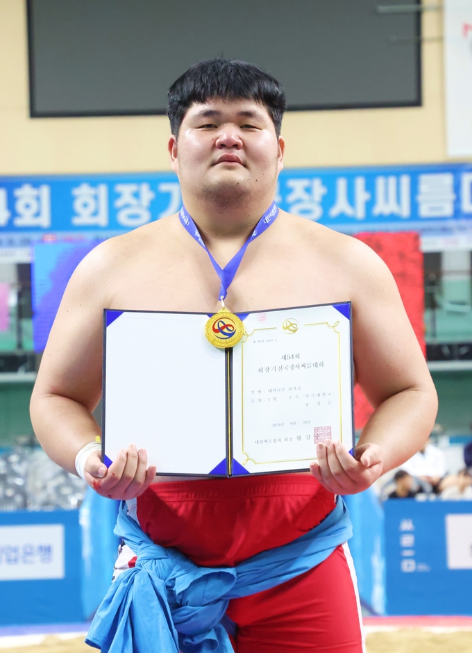 28일 경북 문경시 문경실내체육관에서 열린 제54회 회장기전국장사씨름대회 대학부 장사급에서 1위를 차지한 유경준(경기대)이 메달을 메고 상장과 함께 기념사진을 찍고 있다. (사진=대한씨름협회 제공)