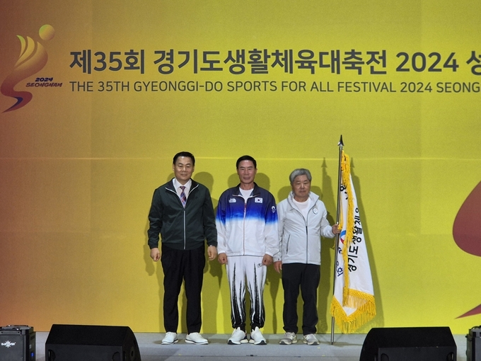 29일 성남종합스포츠센터 1층 다목적체육관에서 진행된 제 35회 경기도생활체육대축전 폐회식에서 대회기를 넘겨받은 다음 개최지 파주시 김종훈 체육회장(오른쪽)과 이원성 경기도체육회장(가운데), 제 35회 개최지였던 성남시 이용기 체육회장(왼쪽)이 기념 사진을 찍고 있다. (사진=이건우 기자)