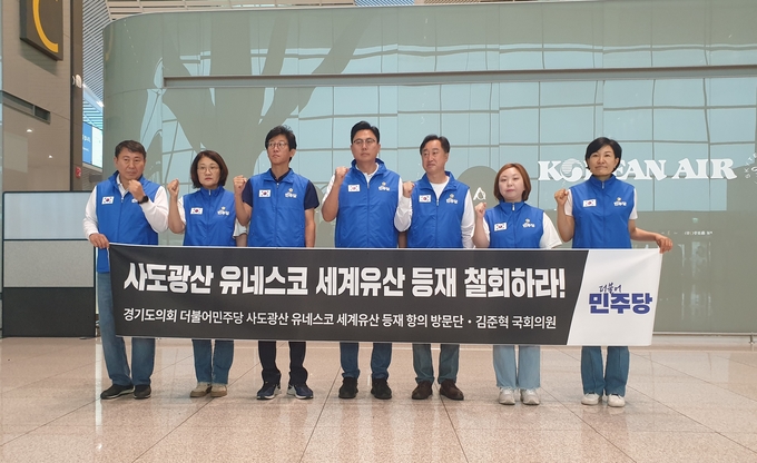 더불어민주당 김준혁(수원정) 국회의원과 이용욱(파주3), 전자영(용인4), 명재성(고양5), 신미숙(화성4), 이채명(안양6), 국중범(성남4) 등 경기도의원이 1일 인천국제공항에서 일본 사도광산의 유네스코 세계유산 등재 철회를 촉구하는 내용의 현수막을 들어 올리고 있다. (사진=나규항 기자)