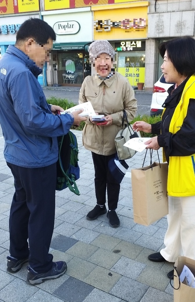 위기가구 및 복지사각지대 발굴을 위한 거리 가두캠페인을 벌이고 있는 지역사회보장협의체 한 위원이 시민에게 안내문을 전달 설명을 하고 있다. (사진=김포시 고촌읍 제공) 