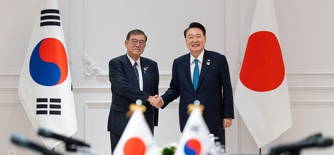 윤석열 대통령이 10일(현지시간) 라오스 비엔티안의 한 호텔에서 열린 한일 정상회담에서 이시바 시게루 일본 신임 총리와 악수하며 기념촬영을 하고 있다. (사진=연합뉴스)