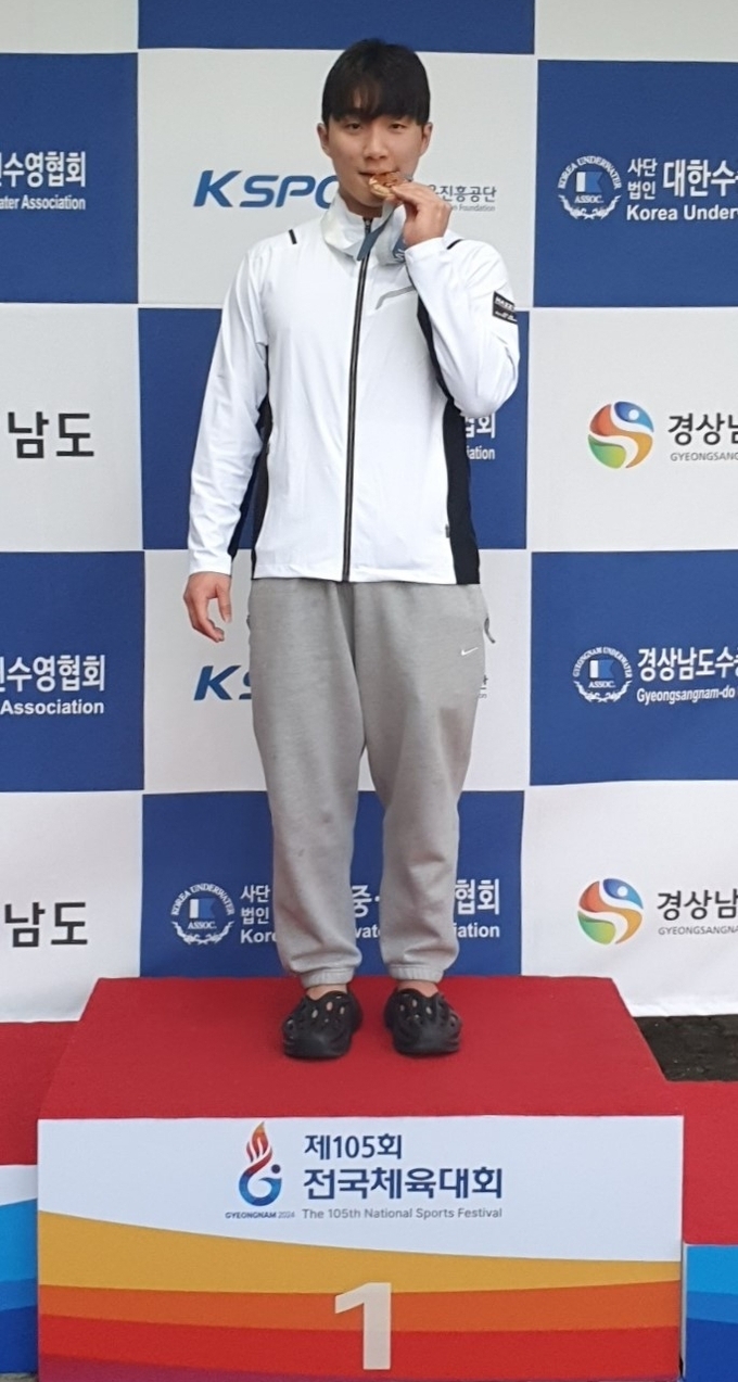 12일 경남 대구시 대구체고수영장에서 열린 제105회 전국체육대회 이틀째 핀수영 남자 일반부 호흡잠영 100m 결승에서 신기록을 세운 신명준이 금메달을 입에 물고 기념촬영을 하고 있다. (사진=경기도청 실업팀 제공)
