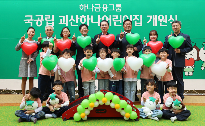강성묵 하나금융그룹 부회장(맨 뒷줄 왼쪽 4번째)이 개원식에 참석해 송인헌 괴산군수(맨 뒷줄 왼쪽 5번째)와 어린이집 원장, 학부모, 어린이, 내외빈들과 기념촬영을 하고 있다. (사진=하나금융그룹 제공)