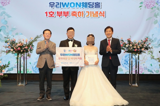 (왼쪽부터) 조병규 우리은행장, ‘우리 WON 웨딩홀’ 1호 부부, 김현훈 서울특별시사회복지협의회장이 기념촬영을 하고 있다. (사진=우리금융그룹 제공)