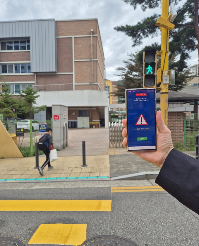 횡단보도에서 녹색신호 시 스마트폰 화면 차단 서비스가 실행되고 있다. (사진=부천시 제공)