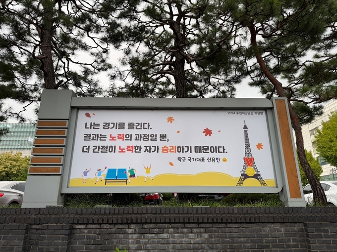 수원시청 외벽에 탁구 국가대표 신유빈 선수의 메시지를 담은 수원희망글판 가을편이 게시돼 있다. (사진=수원시 제공)