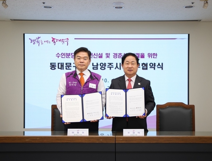주광덕(오른쪽) 남양주시장과 이필영 서울 동대문구청장이 ‘경춘-수인분당선 직결 업무협약' 체결서를 들어보이고 있다. (사진=남양주시 제공)
