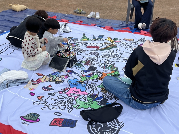 제30회 수원시민통일한마당에 마련된 큰 기 만들기 체험에 아이들이 참여하고 있다. (사진=장진 기자)