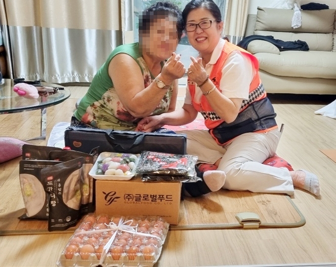 김포소방서 마산 여성의용소방대 위원이 한 취약계층 가정을 방문해 생필품을 전달 기념사진을 찍고 있다. (사진=김포소방서 제공)