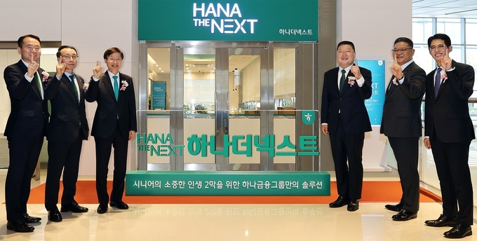 이승열 하나은행장(왼쪽 3번째)과 ‘하나 더 넥스트’의 광고모델 방송인 강호동(오른쪽 3번째)이 하나은행 임직원과 함께 그룹 시니어 특화 브랜드 ‘하나 더 넥스트’의 출범을 알리는 현판식 진행 후 기념촬영을 하고 있다. (사진=하나금융그룹 제공)