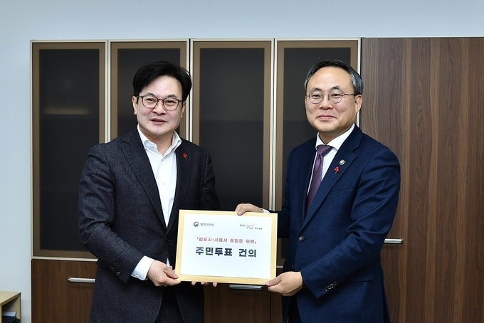 지난해 12월 20일 김병수(왼쪽) 김포시장이 고기동 행정안전부 차관을 만나 김포-서울시 통합을 위한 주민투표 건의문을 전달하고 있다. (사진=김포시 제공)