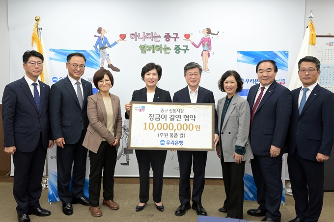 김길성 중구청장(오른쪽 4번쨰), 김정안 중구 전통시장 상권발전소 대표(오른쪽 2번째), 정현옥 우리은행 금융소비자보호그룹장(왼쪽 4번째)이 관계자들과 기념촬영을 하고 있다. (사진=우리은행 제공)