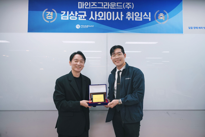 23일 오전 마인즈그라운드 본사 대회의실에서 열린 취임식에서 민환기 마인즈그라운드 대표(오른쪽)가 김상균 사외이사에게 취임패를 전달하고 있다. (사진=마인즈그라운드 제공)