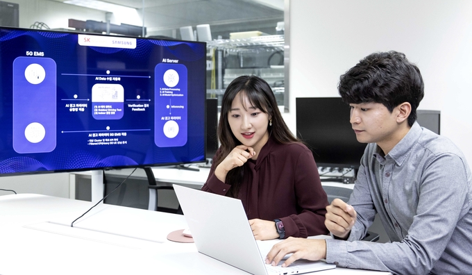 SK텔레콤과 삼성전자 연구원이 AI 기반 5G 기지국 품질 최적화 기술 실증에 대해 논의하는 모습. (사진=SK텔레콤 제공)