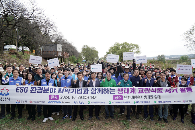 성남시가 ESG 환경 분야 협업 기업 8곳 임직원 등과 탄천 일대 생태계 교란 식물 제거 활동 벌였다. (사진=성남시 제공)