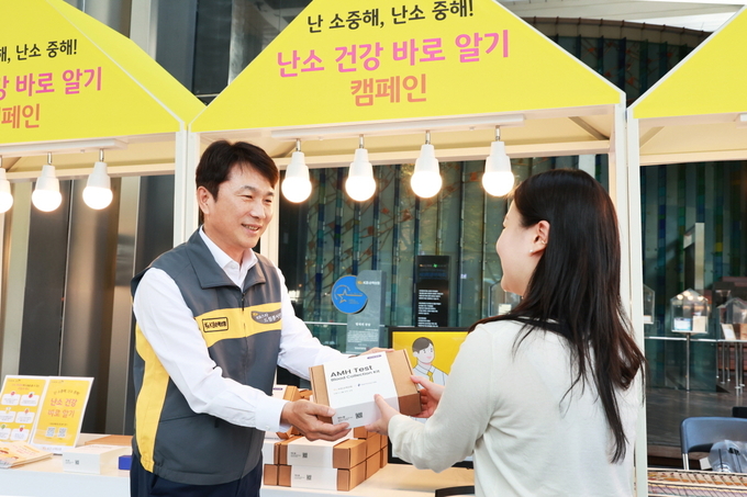 구본욱 KB손해보험 사장이(왼쪽)이 행사에 참여한 여성에게 난소 나이 자가검사 진단 키트를 전달하고 있다. (사진=KB손해보험 제공)