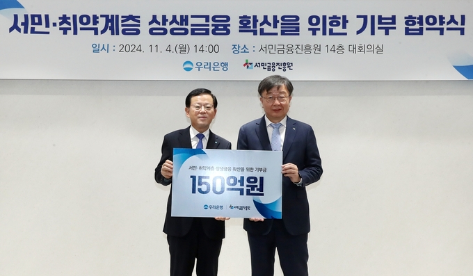 조병규 우리은행장(왼쪽)과 이재연 서민금융진흥원장이 기부 협약식에서 기념촬영을 하고 있다. (사진=우리은행 제공)