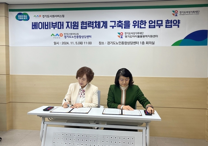 지난 5일 경기도인재개발원에서 진행된 업무협약식에서 박순덕 경기도아이돌봄광역지원센터장과 김향자 경기도노인종합상담센터장이 협약서에 서명하고 있다. (사진=경기도 제공)