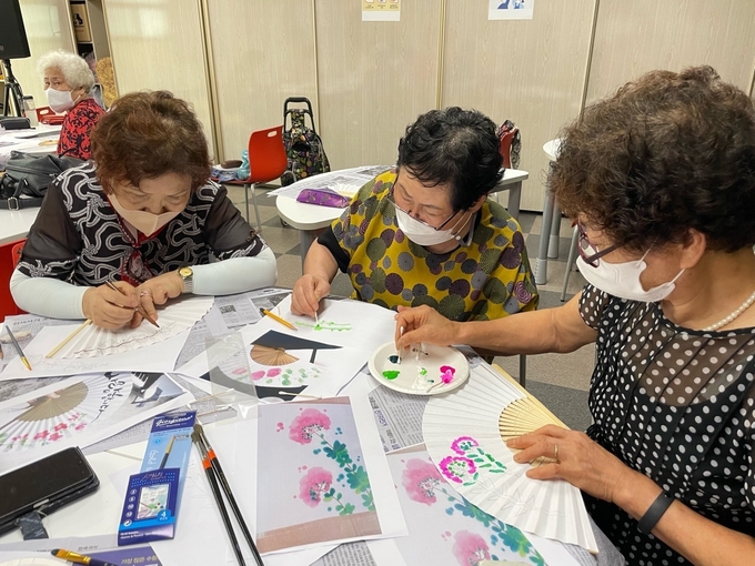 '성인문해교실‘ 에 참여한 어르신들이 특별활동으로 부채를 만들고 있다. (사진=부천시 제공)