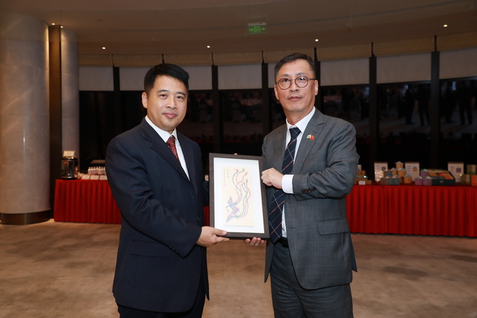오민범 수원시 미래전략국장(오른쪽)이 주하이시 관계자에게 기념품을 전달하고 있다. (사진=수원시 제공)